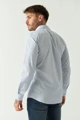 Camisa de hombre de corte slim fit, confeccionada en algodón con diseño de rayas verticales finas en tonos claros. Presenta cuello clásico, cierre frontal con botones y logo bordado en el pecho.