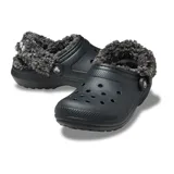 Zuecos Crocs Classic con forro interior de piel sintética tipo sherpa, color gris claro. Presentan el diseño icónico de la marca con perforaciones en la parte superior y correa pivotante en el talón para mayor sujeción.