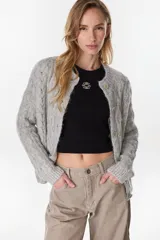 Cardigan tejido de punto gris, de corte relajado, con cuello redondo y cierre frontal de botones.