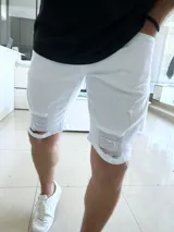 Bermuda de jean blanca con roturas en ambas piernas.