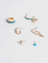 Set de seis aros dorados con detalles celestes. Incluye un aro tipo cuff, dos aros tipo argolla, un aro con forma de eslabón y dos aros tipo botón, uno con forma de corazón celeste y otro con tres strass.