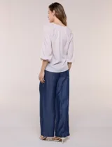 Blusa de gasa liviana blanca con estampado floral en tonos azules y rosados, escote en V, mangas 3/4 abullonadas con puños elásticos y corte fluido.