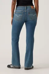 Jeans de mujer de tiro bajo, color azul medio con efecto lavado, corte bootcut y cierre de botón y cremallera.