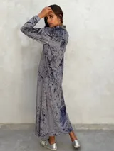 Vestido camisero largo de terciopelo gris con efecto tie-dye, cuello camisero, mangas largas y abertura lateral.