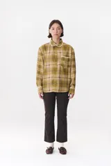 Camisa de corte holgado en color bordó con estampado de cuadros y monograma. Presenta cuello redondo con borde de puntilla, bolsillo frontal con detalle de puntilla, cierre frontal con botones y puños con terminación en puntilla.