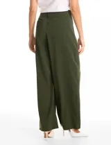Pantalón de corte palazzo en color verde militar, con tiro alto, doble abotonadura frontal y pinzas. Presenta una silueta de pierna ancha, bolsillos laterales funcionales y cintura elástica en la parte posterior.