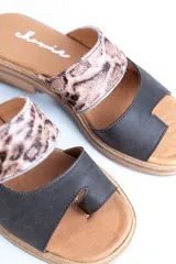 Sandalias bajas de cuero con dos tiras, una de cuero liso color gris y otra con estampado animal print.