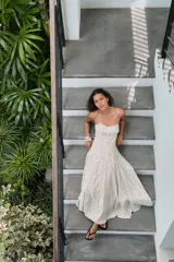 Vestido midi de corte fluido con escote halter y lazada ajustable al cuello. Presenta un diseño con estampado de lunares y falda con volumen.