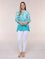 Blusa azul y blanca con estampado floral y geométrico, de calce suelto, con escote redondo, abertura tipo keyhole en el pecho, mangas tres cuartos y ruedo amplio con silueta evasé.