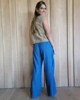 Pantalón de algodón color arena, de corte recto y holgado, con cintura elástica y detalle de costuras horizontales decorativas en la parte inferior de las piernas.