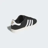 Championes Adidas Jabbar Lo de diseño clásico y minimalista, con parte superior de cuero negro, las icónicas tres franjas laterales en blanco y suela de goma en tono crema.