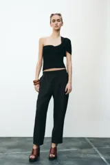 Pantalón tobillero color beige, con cintura elástica ajustable con cordones, bolsillos delanteros y falsos bolsillos con solapa en la espalda.