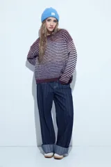 Sweater de tejido de punto con diseño de rayas horizontales en tonos bordó y celeste. Presenta cuello redondo, corte holgado y mangas largas con puños ajustados.