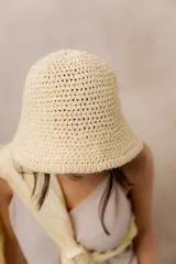 Gorro tipo bucket tejido a crochet de trama abierta, color natural, con ala corta y flexible.