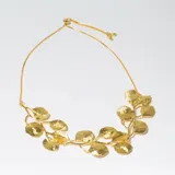 Collar dorado con cadena fina y dije de hojas.