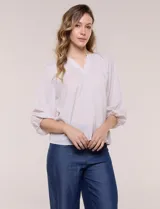 Blusa de gasa liviana blanca con estampado floral en tonos azules y rosados, escote en V, mangas 3/4 abullonadas con puños elásticos y corte fluido.