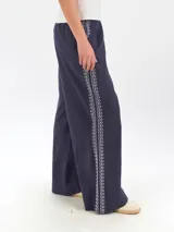 Pantalón ancho de lino color azul marino, de tiro alto, con bordado decorativo en color blanco en los laterales.
