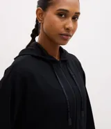 Campera deportiva de corte regular confeccionada en modal, con cierre frontal por cremallera, capucha con cordón ajustable, mangas largas con puños elásticos y bolsillos laterales.