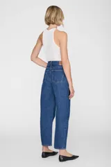 Jean de denim azul de tiro alto, con silueta barrel de pierna curva y diseño clásico de cinco bolsillos.