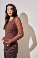Remera de encaje negro ajustada al cuerpo, de manga larga y diseño transparente.