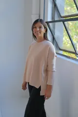 Sweater de tejido de punto color crudo, con cuello redondo, mangas largas y diseño holgado con aberturas laterales en el ruedo.