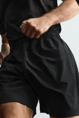 Pantalones deportivos cortos de Zara Athleticz, confeccionados en tejido técnico ligero y elástico. Presentan cintura elástica ajustable con cordón interior, bolsillos frontales, bajo con perforaciones decorativas y aberturas laterales, con detalle de logo estampado en la pierna.