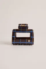 Broche para el pelo tipo clip rectangular con diseño de cuadros en tonos marrón, azul y blanco, con detalle de letra R en color dorado.