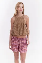 Blusa ballon de lino color tostado, con escote halter y diseño sin mangas con efecto abombado en el ruedo.