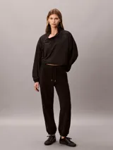 Jogger Calvin Klein de tejido polar color negro, con corte regular, cintura elástica con cordón ajustable y puños elásticos en los tobillos.