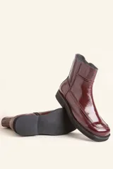 Bota corta de cuero vacuno con acabado charol brillante, diseño de punta cuadrada y suela de caucho con pequeña plataforma.