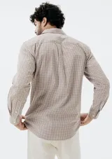Camisa de manga larga con cierre frontal de botones, cuello clásico y bolsillo en el pecho. Presenta un diseño de rayas verticales finas en tonos azul y blanco.