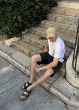 Sandalias de dos tiras marrones de ecocuero estilo Birkenstock, con hebillas metálicas ajustables y plantilla anatómica.