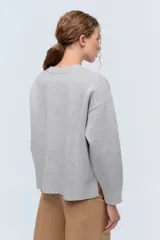 Sweater color camel de tejido de punto con cuello redondo y mangas largas. Presenta bordado de flor en el frente y la palabra 'Rebels' en la manga.