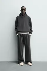 Pantalón jogger de corte wide fit confeccionado en tejido fluido con viscosa. Presenta un efecto lavado, cintura elástica ajustable con cordón, pliegues frontales, bolsillos laterales y un bolsillo trasero de plastrón.