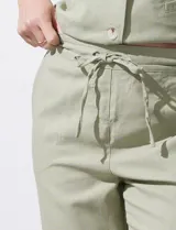 Pantalón de corte recto confeccionado en mezcla de lino, color verde claro. Presenta una pretina ancha con lazo de ajuste frontal y bolsillos laterales verticales.
