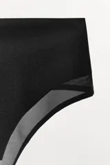 Tanga de tiro alto con cintura ancha, confeccionado en tejido de poliamida con detalles de transparencia en los bordes.