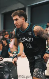 Musculosa de básquet negra con detalles en turquesa, con nombre "Hermod" y número "19" estampados en blanco.