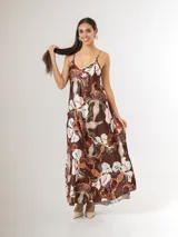 Vestido largo de satén estampado con grandes flores blancas y marrones, tirantes finos regulables y diseño amplio de caída fluida.