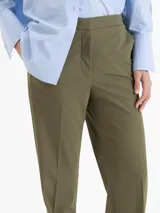 Pantalón de corte recto confeccionado en tela sastrera, con cintura de cuero vacuno, raya marcada en el centro de las piernas y bolsillos laterales.