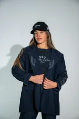 Blazer de lycra color negro, con diseño de solapas amplias y bordados de alas en el frente. Presenta un corte holgado y moderno con mangas largas.