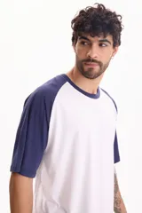 Remera oversize de manga corta raglán, color blanco con mangas y cuello en azul marino.