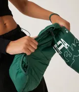 Campera puffer roja, ligera, de poliamida, con capucha y bolsillos con cremallera. Incluye bolsa para guardarla.