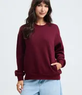 Buzo de cuello redondo y manga larga, confeccionado en algodón con felpa. Presenta un diseño básico con puños y cintura ajustados, e incluye un bolsillo frontal tipo canguro.