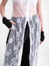 Vestido largo de encaje blanco con diseño de inspiración japonesa, cuello alto, abertura frontal y mangas cortas.