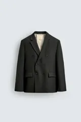 Blazer de corte relajado confeccionada en lana de origen italiano, con diseño de doble botonadura cruzada. Presenta cuello con solapas de muesca, manga larga con botones en puños, bolsillos con solapa en la cadera y abertura central en la espalda. Incluye forro interior a contraste.