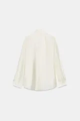 Camisa de tejido satinado con mezcla de lyocell, cuello redondo con escote en pico y lazada frontal. Presenta mangas largas con puños anchos y bajo recto.
