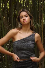 Top tejido con lurex plateado, de un solo hombro y hebilla circular en la tira.