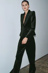 Blazer entallada de Zara Woman Collection confeccionada en tejido de terciopelo. Presenta cuello con solapas de muesca, manga larga con hombreras, bolsillos delanteros con solapa y cierre frontal con un botón. Incluye forro interior.
