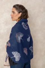 Pashmina reversible de textura suave y caída fluida, con diseño estampado de hojas de ginkgo biloba. Presenta un lado con fondo oscuro y otro con fondo claro, finalizando en ambos extremos con flecos cortos deshilachados.