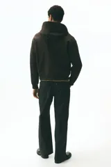 Campera con capucha de H&M, confeccionada en tejido pesado de algodón. Presenta cierre frontal, bolsillos tipo canguro, capucha forrada y puños y bajo acanalados. Diseño de corte holgado.